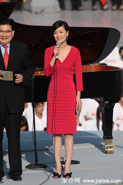 陈蓉手持话筒似在倾听，神情专注尽显专业主持风范