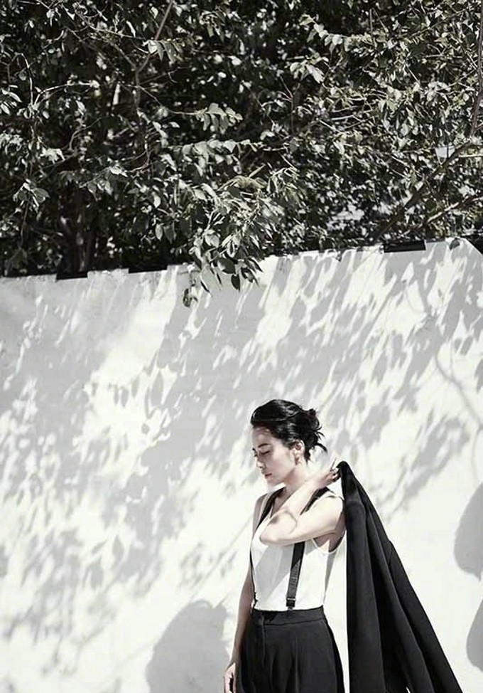 俞飞鸿身着黑色套装优雅端坐，姿态舒展，面容恬淡彰显知性魅力