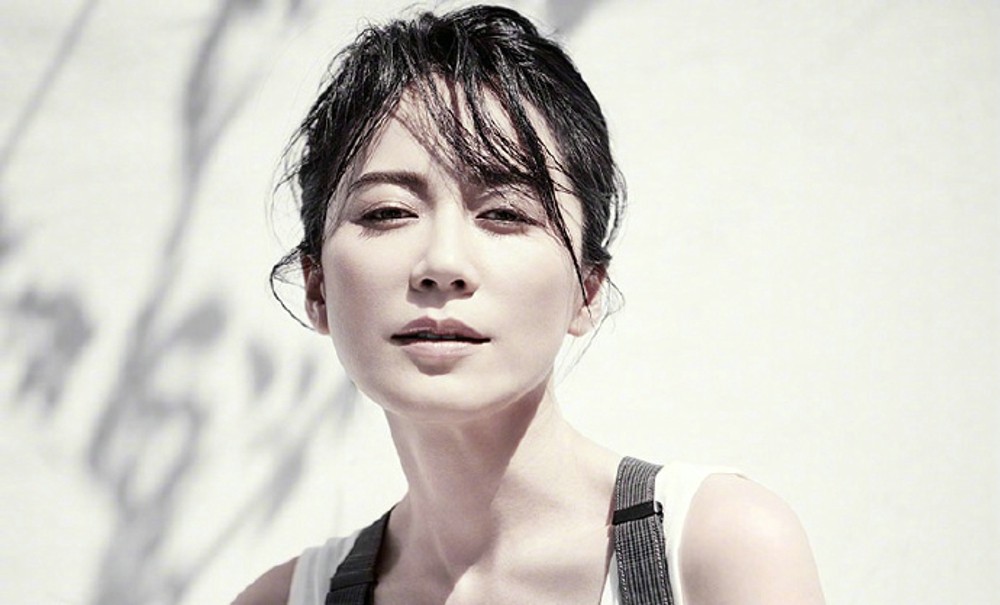 俞飞鸿倚靠窗边沉思，简约服饰与静谧氛围交融，散发静谧力量