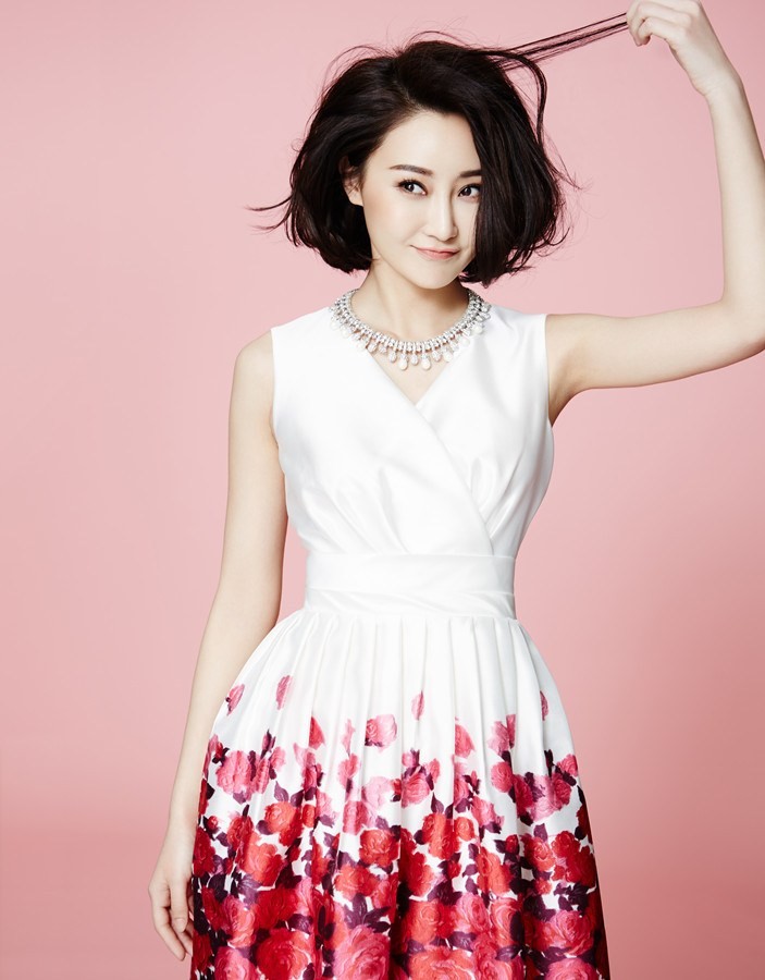 林鹏一袭白色连衣裙，在飘落的花瓣中侧首回眸，眼神清澈灵动如夏日清泉