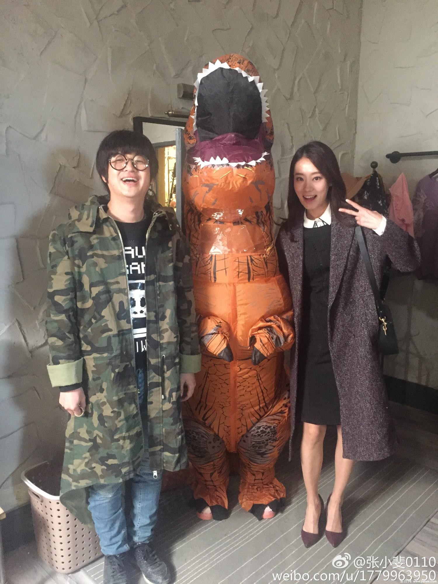 张小斐身穿白色露肩套装立于绿植旁，斑驳光影洒落肩头尽显优雅纯净