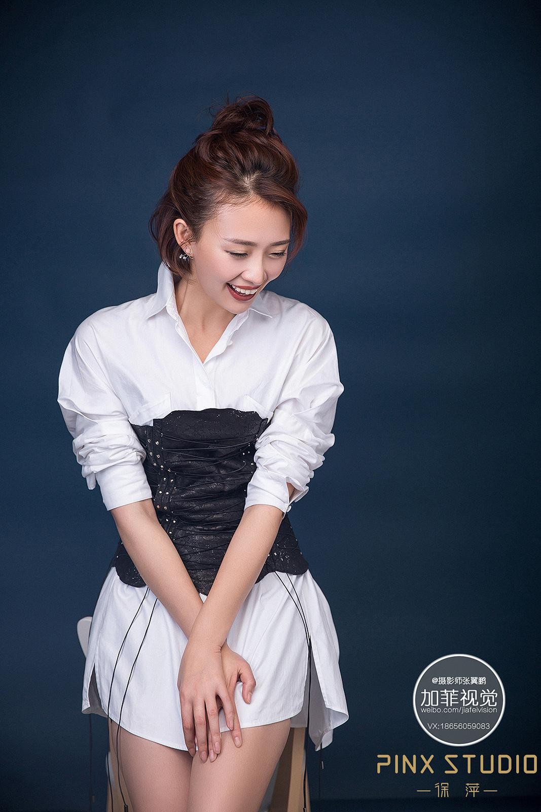 史百惠坐姿优雅，面对镜头眼神温柔而坚定，白色裙装与丝袜尽显知性柔美韵味