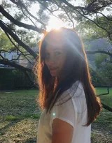 卢靖姗倚靠栏杆，发丝与衣角被风吹起，在黄昏温柔的光晕里，构成一幅充满动态美与故事感的画面