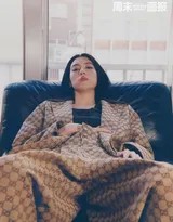 自然光从百叶窗缝隙洒入，照亮空气中浮动的微尘，她身着宽松针织衫回眸，画面静谧而生动