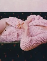 她赤足坐在地板上，手边散落着书本，低头浅笑间流露出难得的温柔与静谧