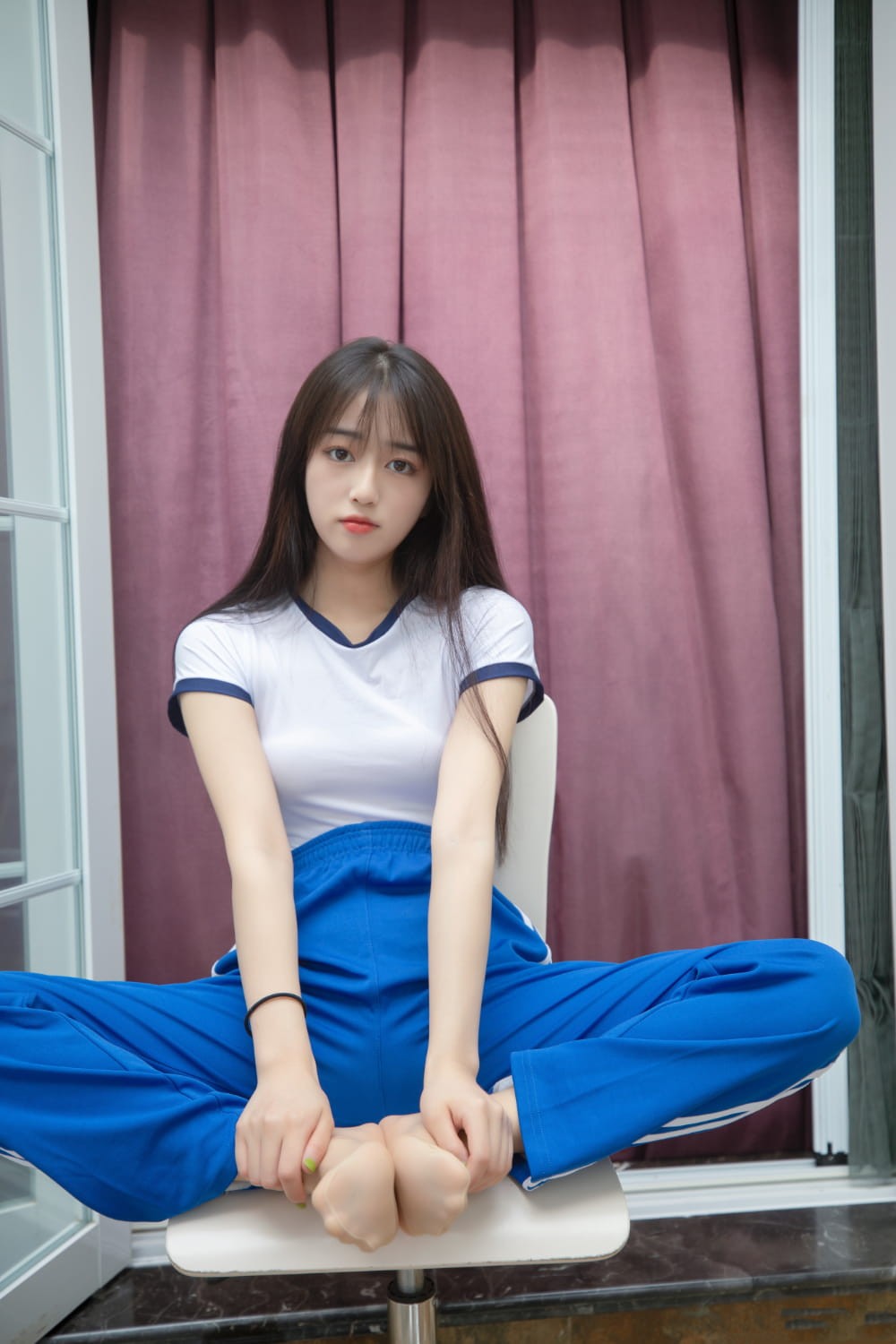 女生倚靠墙壁安静读书，神情专注温柔，仿佛置身于喧嚣世界外的宁静角落