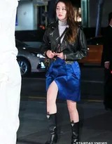 迪丽热巴身着黑色皮衣侧身回望，立体五官与冷艳妆容在光影中宛如精细雕刻的艺术品