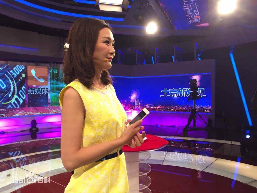 周宇身着一袭白色西装套裙，倚靠在休息室的桌旁，侧首微笑散发出知性与温柔并存的气质