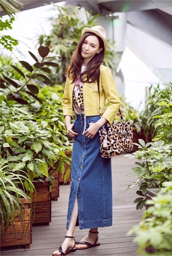 唐嫣手提精致挎包行走于春光中，整体造型洋溢明媚活力