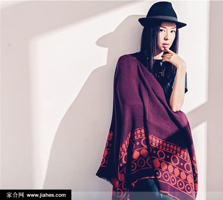 张静初倚靠玻璃幕墙，侧首浅笑，米色针织衫与午后阳光交织出温柔光晕