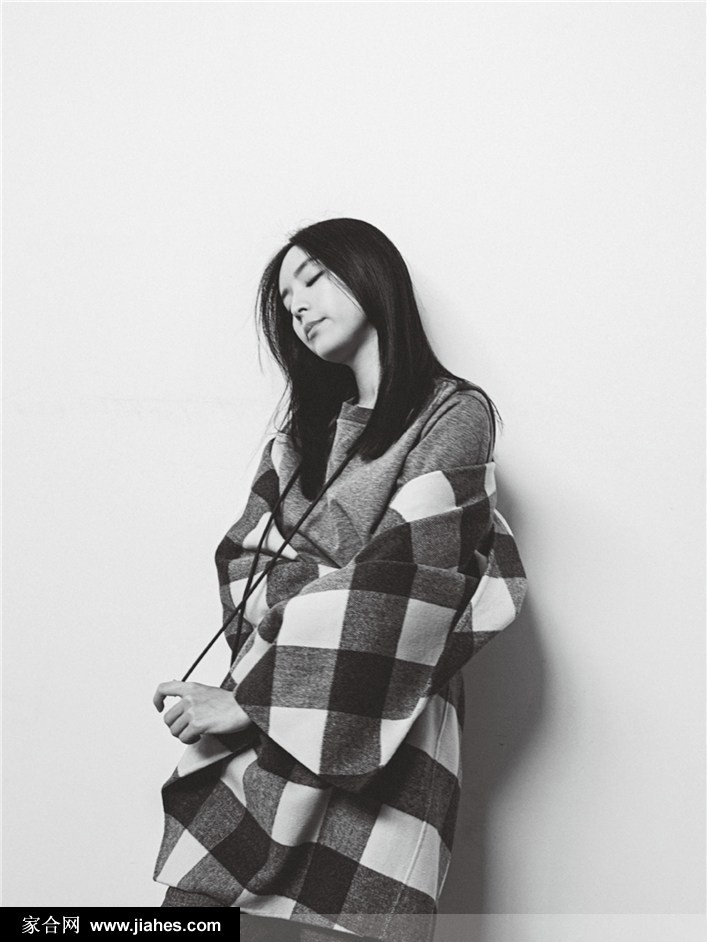 张静初背影伫立窗前，逆光勾勒身形轮廓，都市楼宇化作朦胧背景，意境深远