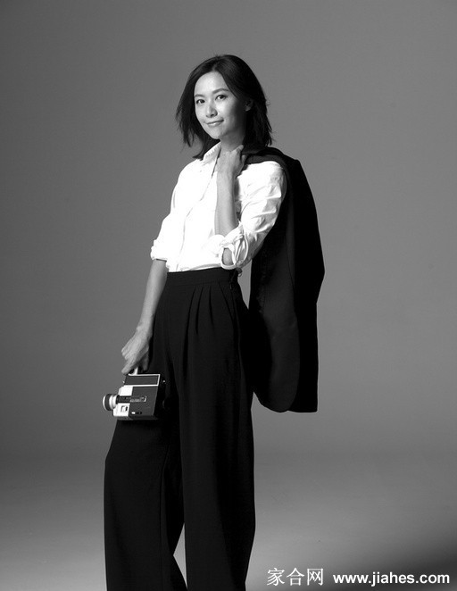 徐静蕾身着简约灰色T恤怀抱孩童，笑容温柔散发恬淡母性光辉