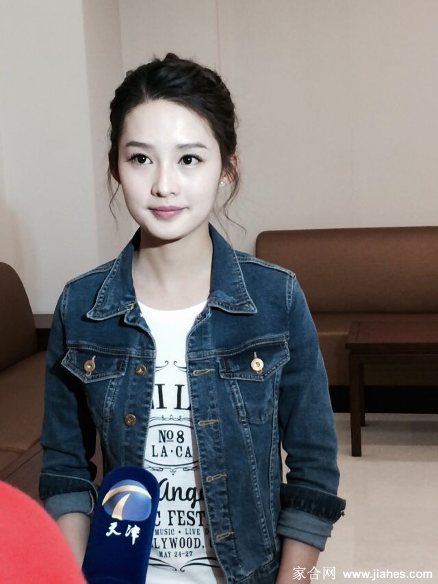 李沁蹲下身来，目光平视一位身穿蓝色上衣的小男孩，她伸出双手，正专注地引导孩子进行互动游戏，眼神里满是鼓励与温柔。