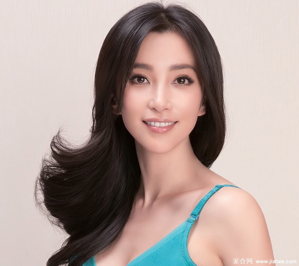 李冰冰身穿粉色抹胸洋装手提同色包包，于城市街角展露俏皮甜美的笑容