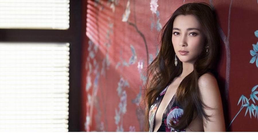 李冰冰身影朦胧隐于巨型幻彩花朵之后，营造出一种神秘、深邃且充满哲思的视觉氛围