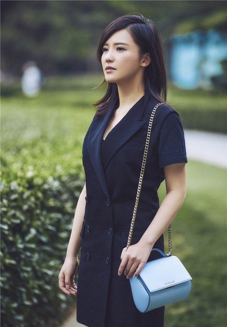 杨子姗倚靠墙面，拼色皮夹克与皮裤搭配展现酷感，微微凌乱的头发增添随性魅力