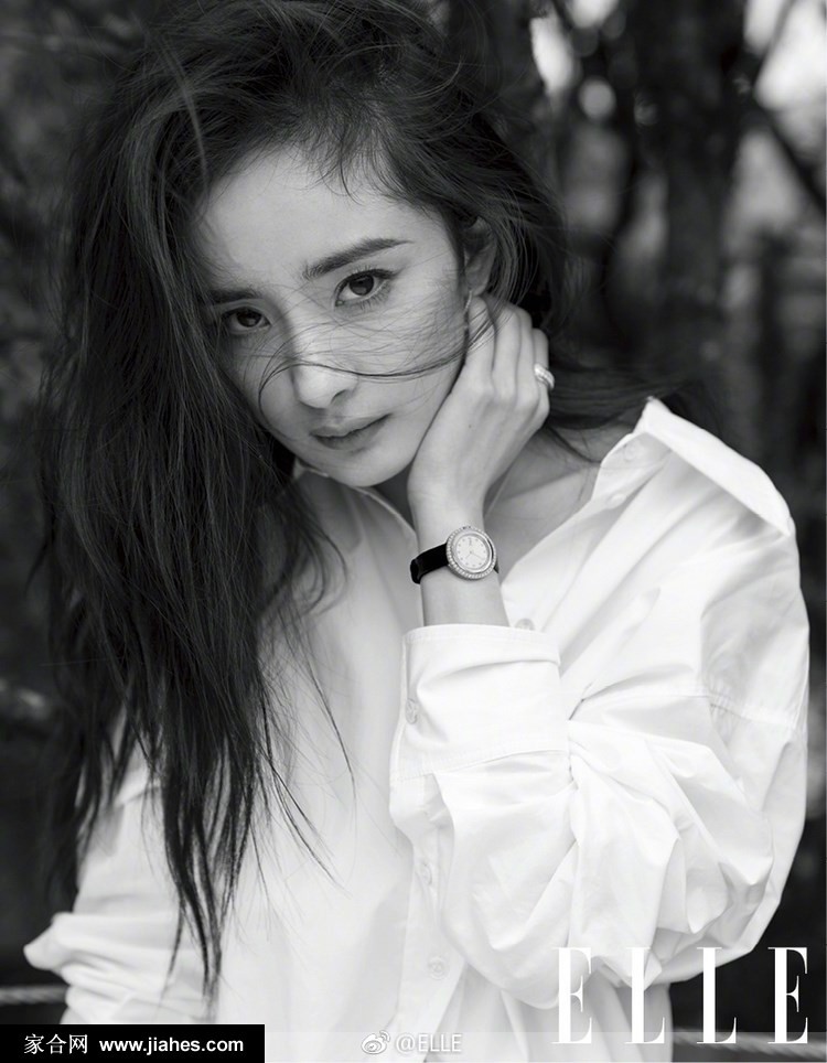 杨幂微卷长发垂落肩侧，一抹淡然笑意点缀清冷面庞