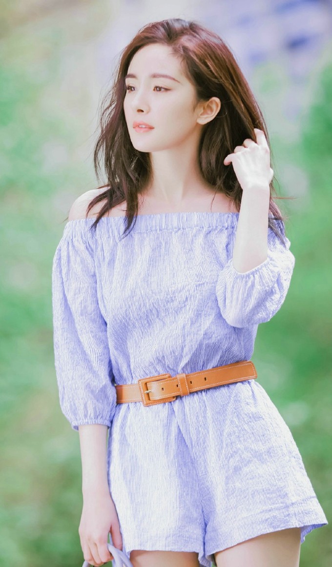 杨幂身着浅色吊带裙侧身回眸，眼神清澈灵动，宛如夏日邻家少女