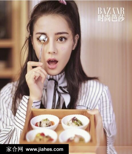 迪丽热巴侧首回眸，眼神狡黠如林间小鹿，蓬松卷发映衬精致侧颜