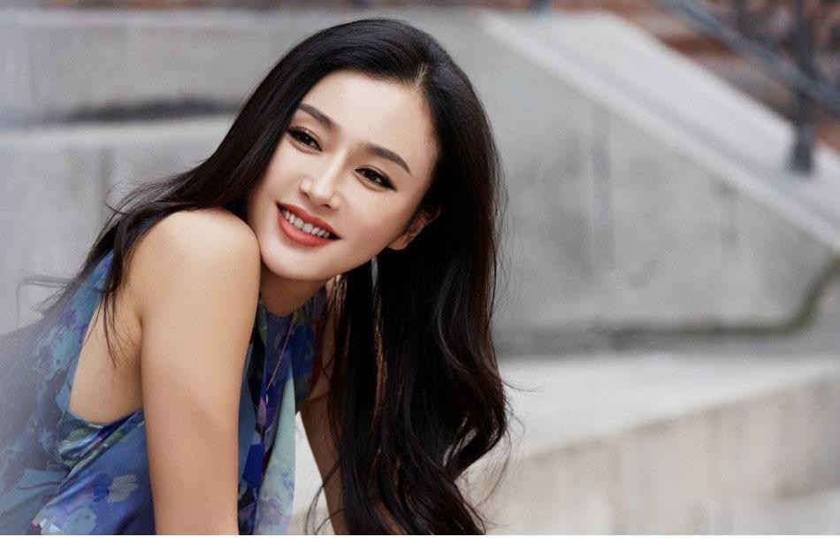 秦岚身穿淡粉色纱裙倚坐窗边，午后阳光轻抚面庞展露温柔浅笑