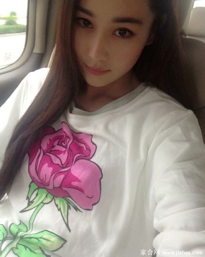 她低头浅笑，指尖轻抚书页，午后阳光为她的温柔轮廓镀上金色光边