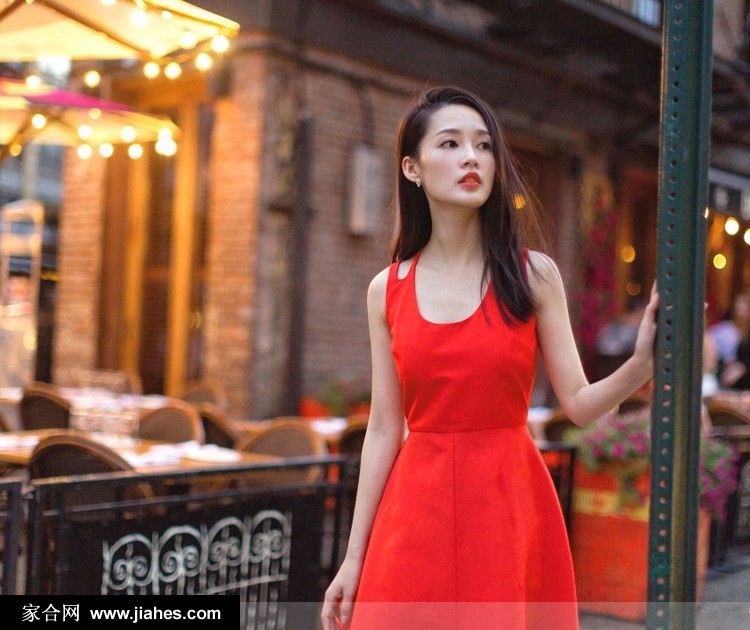 李沁手持鲜花点缀，置身古典窗棂前，红裙与背景交融出复古时尚感