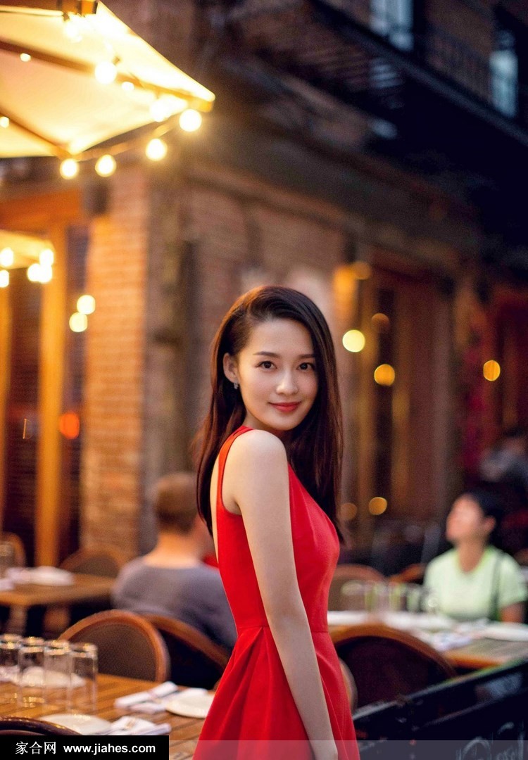 李沁面对镜头展露明媚笑容，雪白肌肤与红裙相映成趣，宛如古典画中人