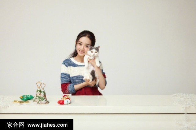 赵丽颖以手轻撩蓬松卷发，对镜头展露自信而略带俏皮的微笑