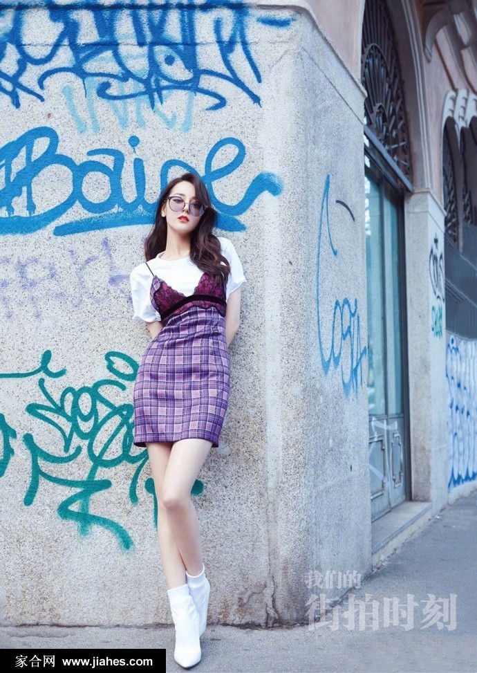 远景中迪丽热巴背影翩跹，都市街景成为其展现时尚魅力的绝佳舞台