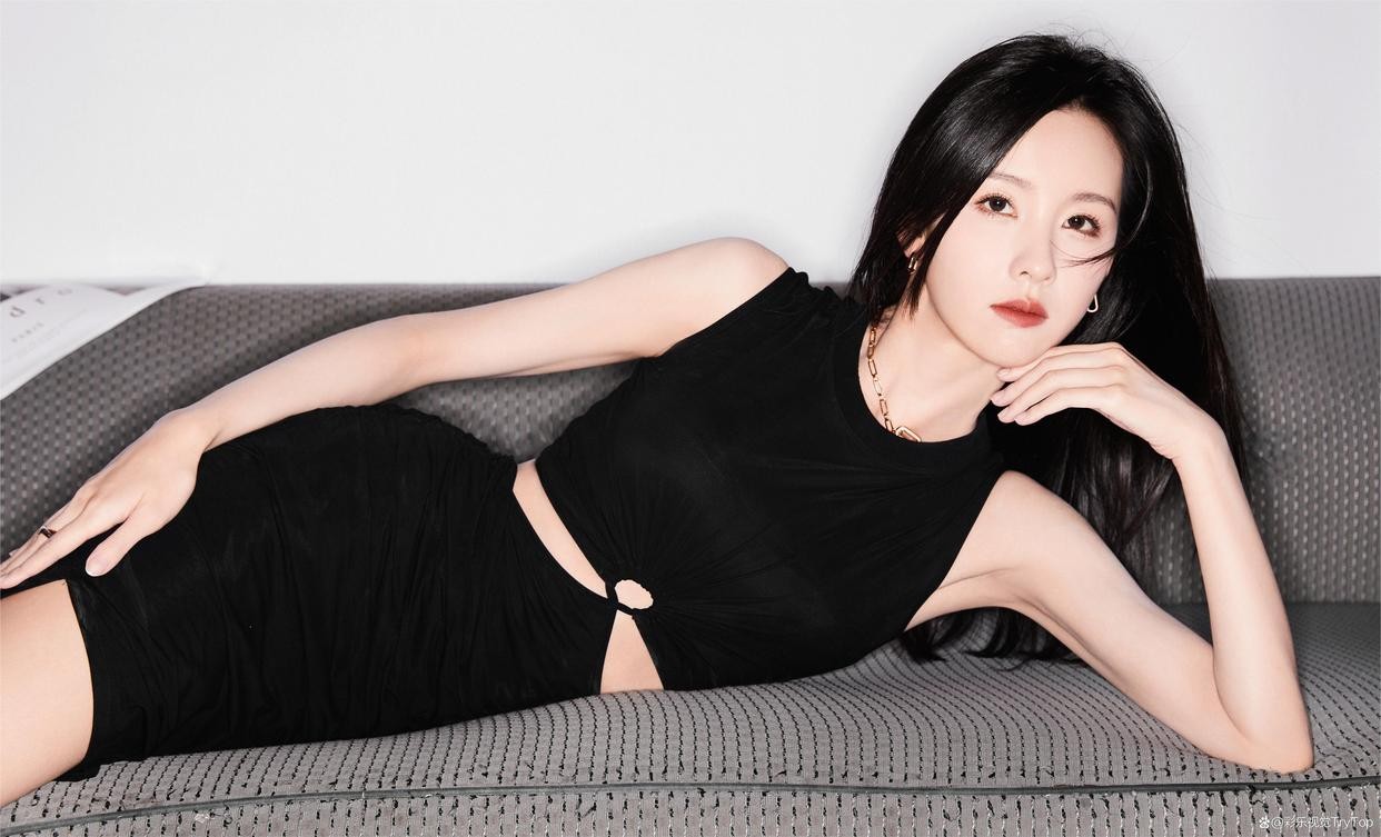 陈都灵倚靠于现代风格廊柱旁，黑色裙摆轻垂，腿部线条在光影中延伸