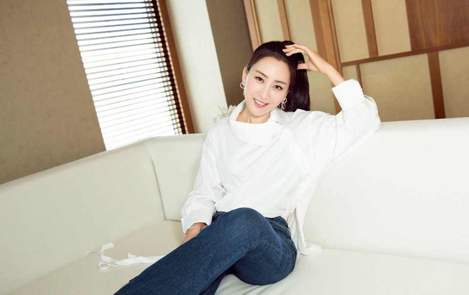 镜头特写下，马苏衬衫的细腻面料质感与精巧袖口设计清晰可见，她的表情淡然自信，诠释了何为简约而不简单