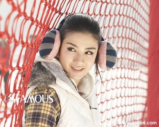 黄奕身着浅色衣裙立于雪原，发丝与裙摆随风轻扬，静谧中蕴含力量