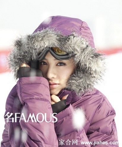 黄奕手持雪仗露出自信笑容，滑雪服色彩鲜艳如冬日里跃动的火焰