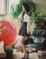 倚靠窗边的职业美女，阳光洒落肩头，白衫黑裙勾勒出流畅曲线