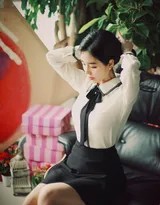 私房环境中美女慵懒坐姿，柔美气质在黑裙白衫间自然流露