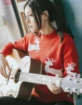 双马尾造型的莫小琪在柔和灯光下专注弹奏木吉他，营造出温馨的居家氛围