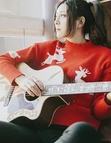 莫小琪低头浅笑，双手优雅地按着吉他和弦，发丝自然垂落肩头