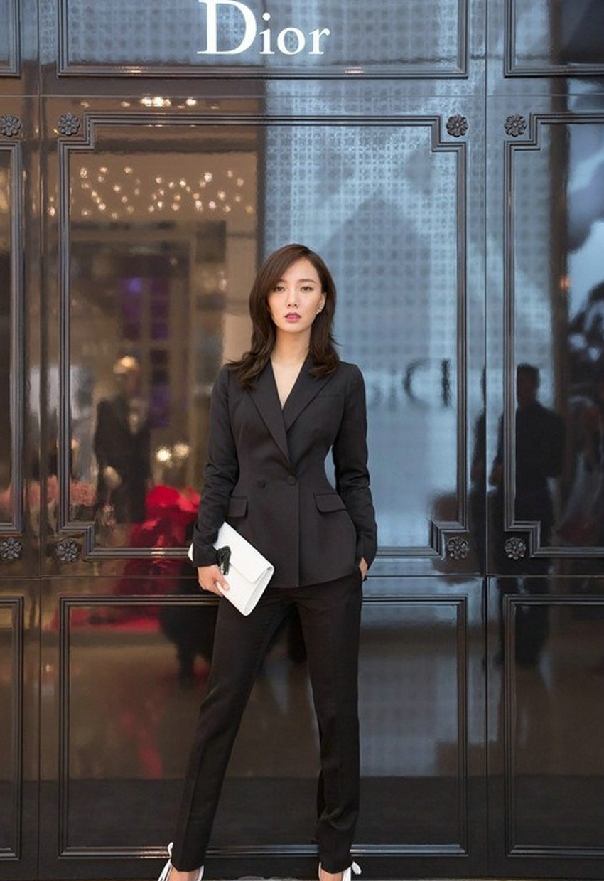 王珞丹身着黑色修身裤装侧身而立，腿部线条流畅修长，光影勾勒出优雅身形