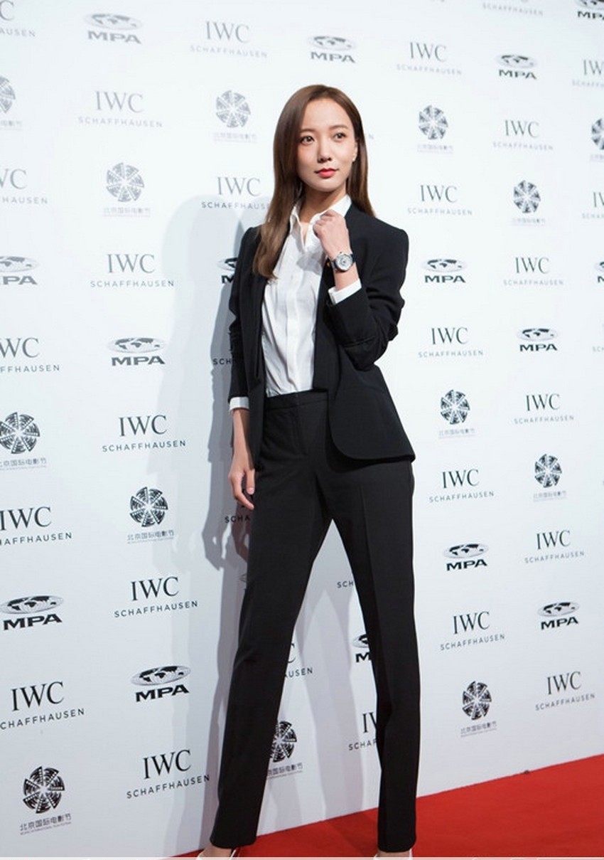 王珞丹身穿经典黑白配裤装，双手插袋姿态潇洒，尽显都市女性的摩登风范