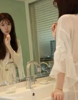 身着粉色蕾丝睡裙的少女倚靠于沙发，晨曦为她的轮廓镀上一层柔和光晕，微卷长发散落肩头，眼神中带着初醒的朦胧与笑意