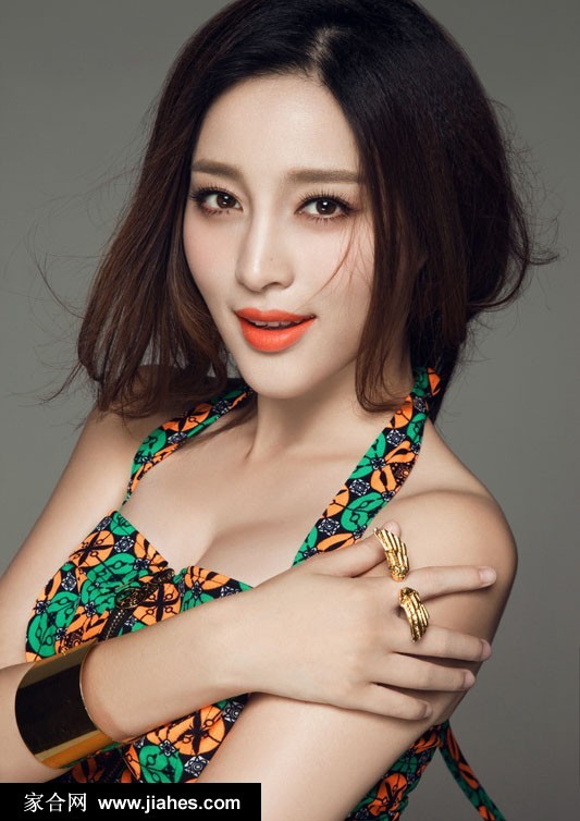 甘婷婷置身于简约背景前，肢体语言轻松自然，诠释了轻熟女性自信洒脱的时尚态度