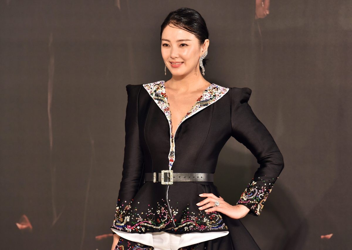 张雨绮坐于高脚凳上，双腿交叠，手抚裙摆面露浅笑，展现出从容优雅的御姐风范与强大气场