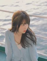 女孩背靠船体，闭目微笑感受海风，发丝与衣角在风中轻扬，尽享此刻宁静