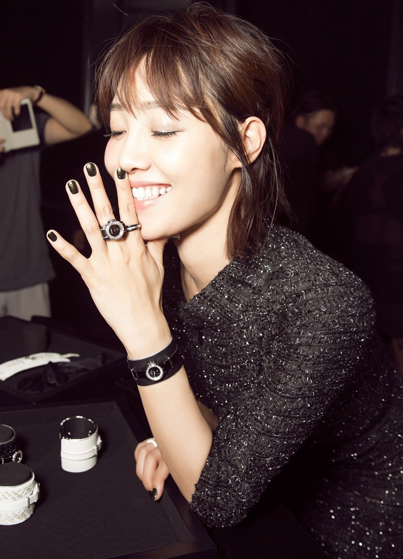 白百何妆容精致，佩戴闪亮耳饰，身着黑色刺绣裙在镜头前绽放自信从容的微笑