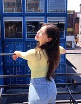 女孩回首浅笑，微风拂动发丝，在集装箱构成的几何背景中定格下温柔瞬间