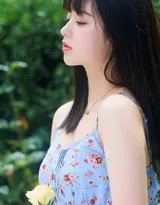 女孩手撑草地，回眸浅笑，眼眸清澈明亮，身后是泛着水光的无垠绿野，洋溢着自由与欢愉。