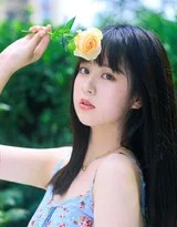 少女躺在如茵绿草上，闭目微笑，双手放松置于身侧，仿佛正做着与蓝天白云相关的美梦。