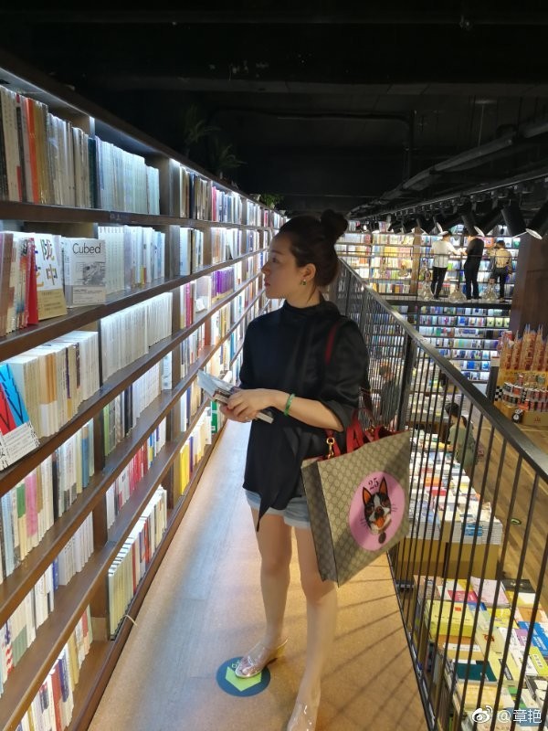 章艳以白色丝袜造型亮相，倚靠窗边目光宁静，尽显恬静柔美的文艺气息