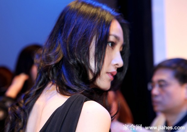 王丽坤身着黑色西装外套搭配碎花长裙，手持精巧提包展现干练与柔美结合的日常时尚