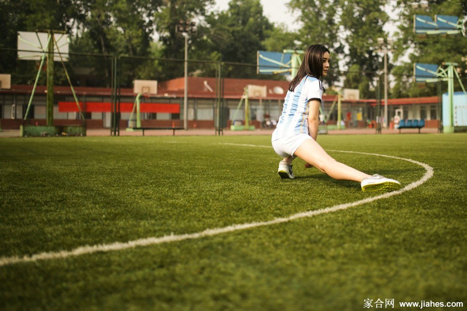 袁姗姗坐于球场边，展现出一份动静结合的随性之美